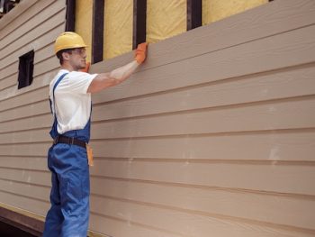 Male Worker Building House At Construction Site